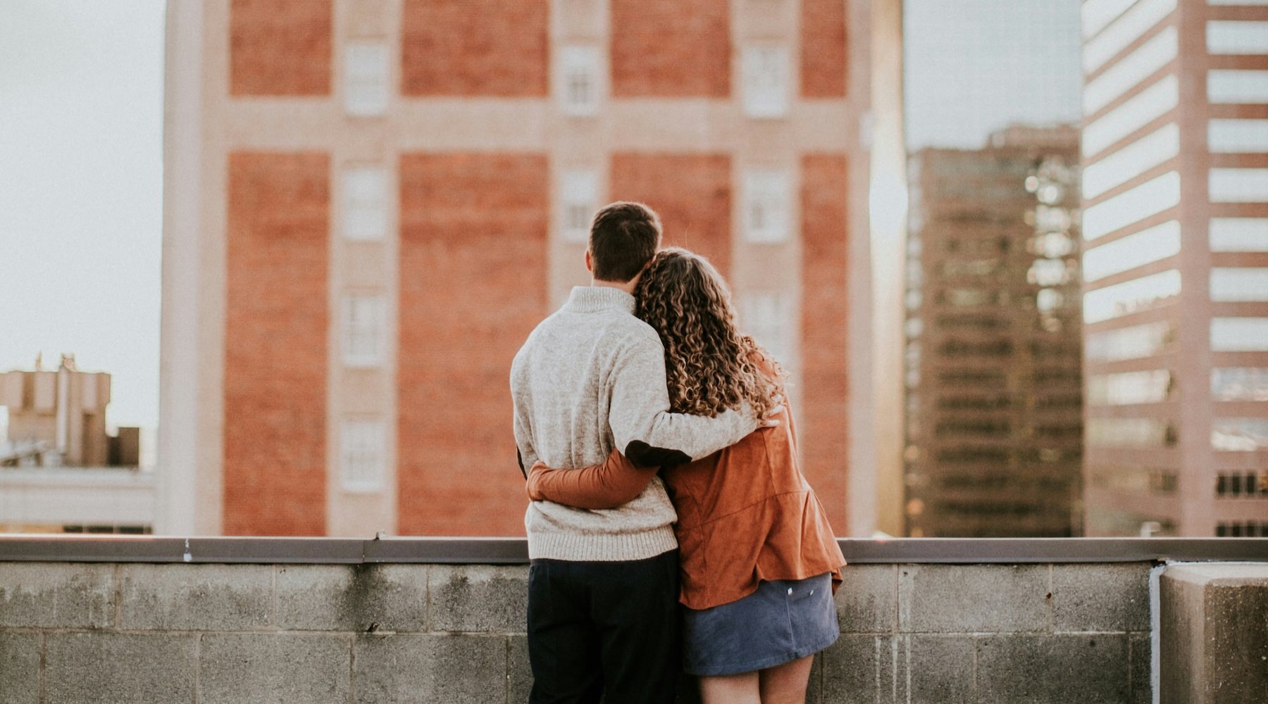 a couple looking at a city from a rooftop